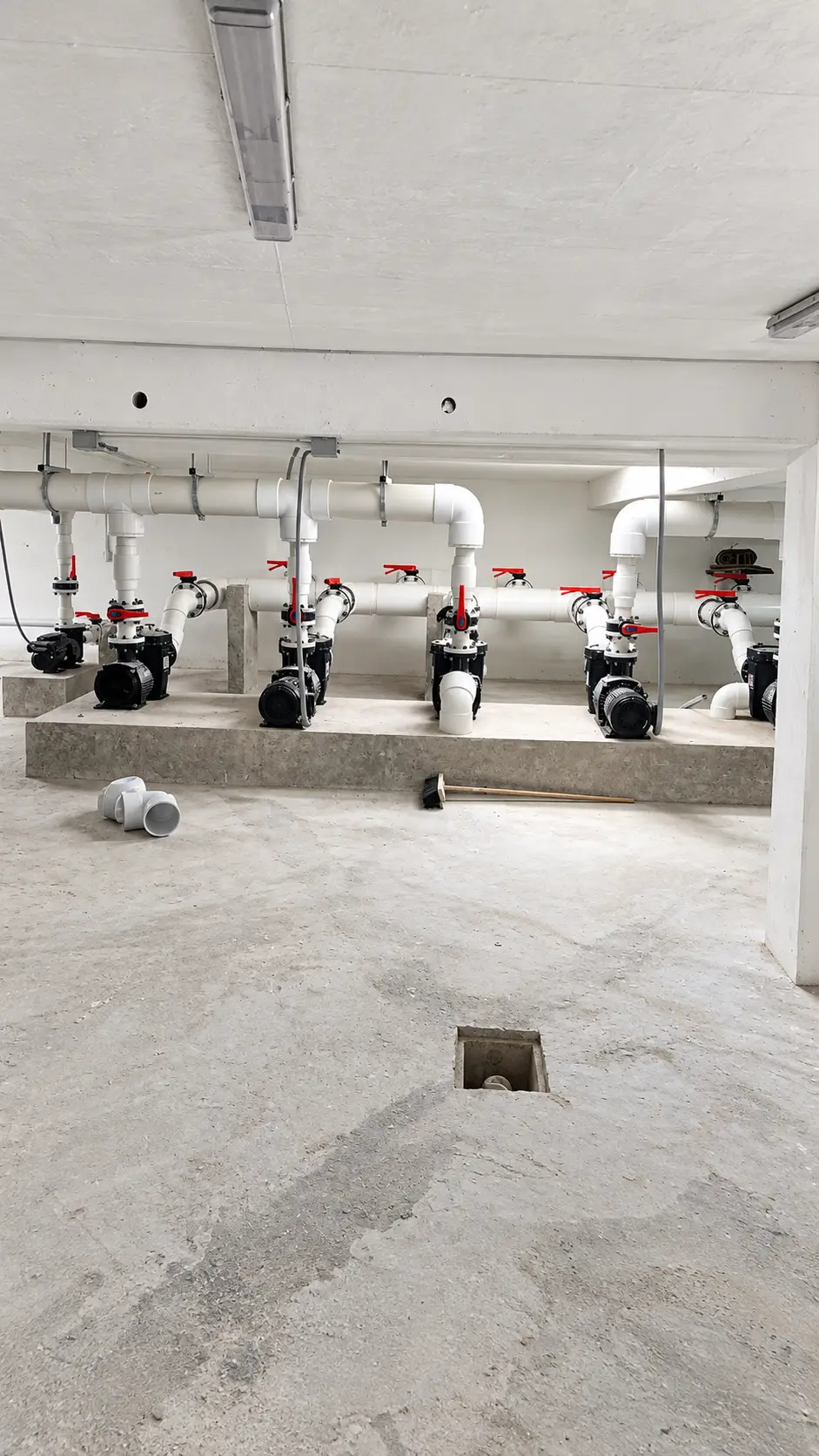sala-de-bombas-negras-sobre-plataforma-de-concreto-con-drenaje-en-piso-compressed